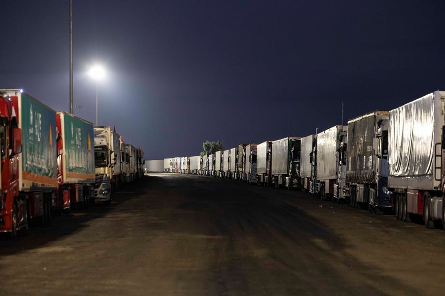 Trucks with aid lined up at the Egypt side of Rafah amid stop–go access