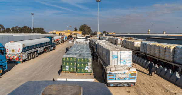 Aid trucks queue on the Egypt side of the Rafah crossing during the first phase of the truce