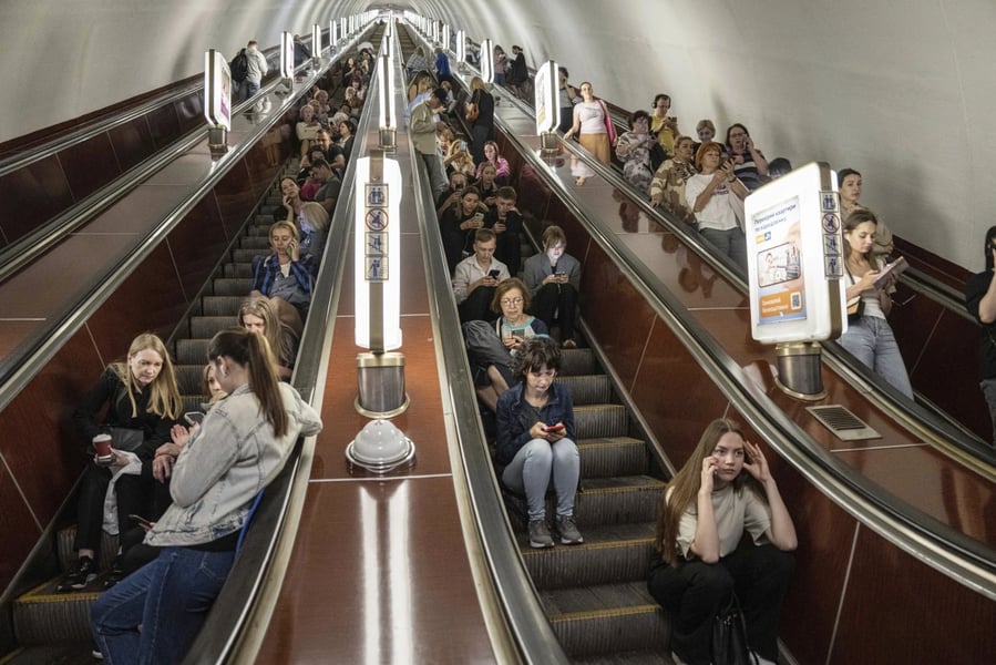 Commuters in a dim metro passage in Kyiv during a planned outage window