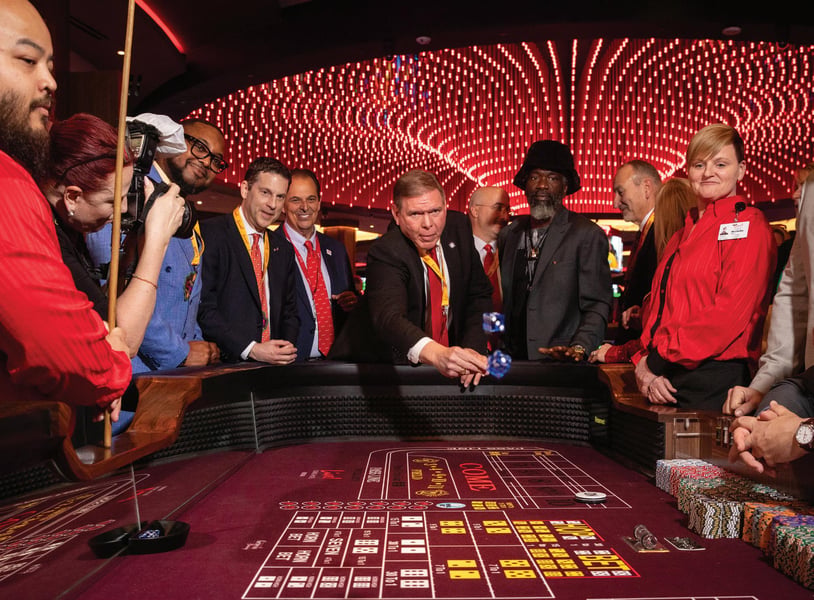 Active casino floor with diverse patrons playing slot machines and table games