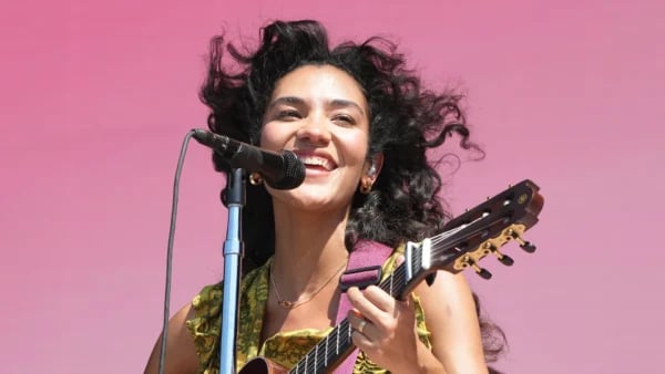 Olivia Dean performing live on stage with fans in the background