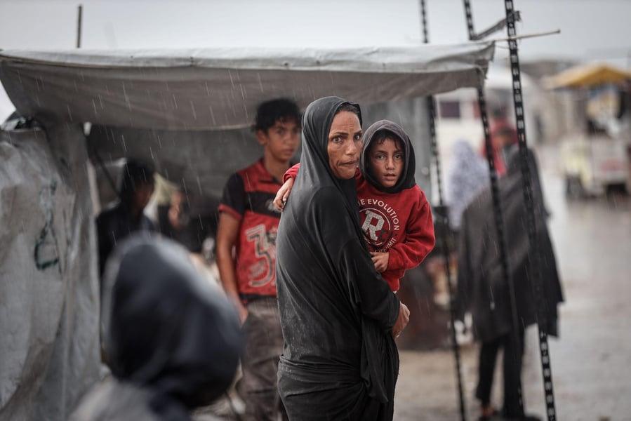 Palestinian children stand in flooded displacement camp during Storm Byron in Gaza December 2025
