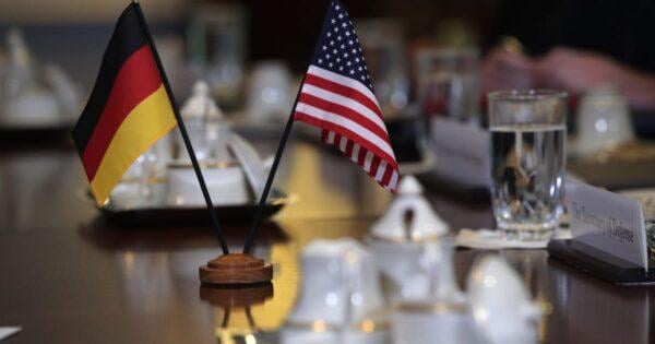 German and American flags representing diplomatic tensions over US visa bans on European activists