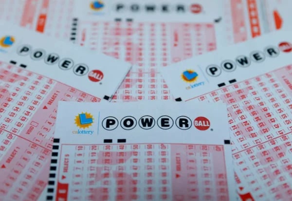 Powerball lottery ticket with $1.7 billion jackpot displayed alongside cash money for Christmas Eve 2024 drawing