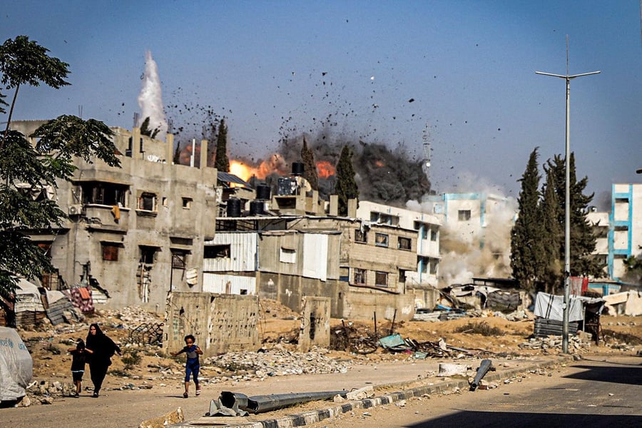 Palestinians walk through destroyed buildings in Gaza after Israeli airstrikes despite ceasefire
