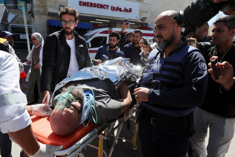 Palestinian paramedics evacuate wounded civilians after an Israeli airstrike in Gaza City.