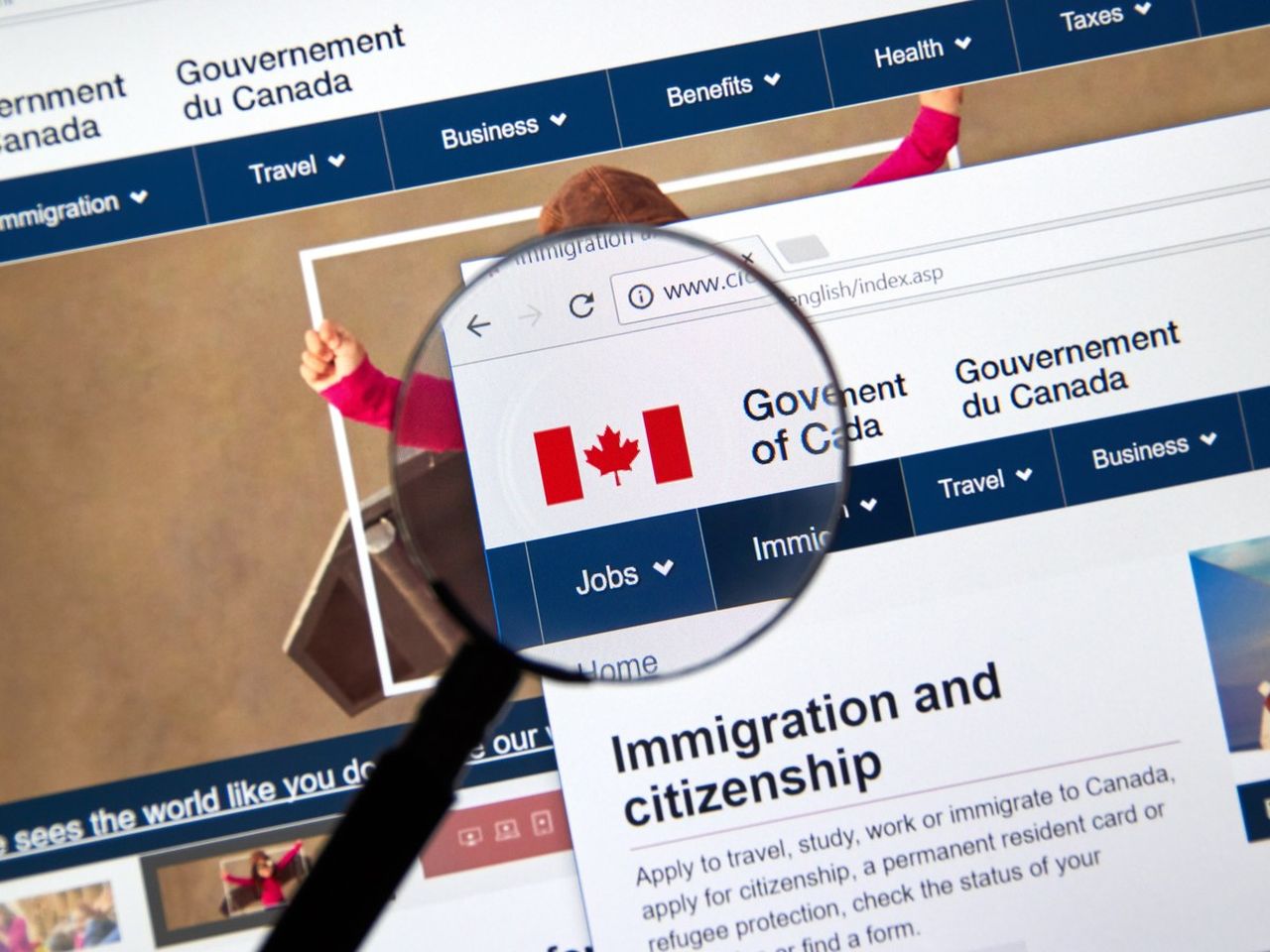 A person holds a Canadian passport and flag at a citizenship application desk