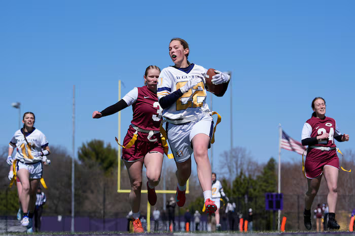 College women’s flag football team gathers during a game