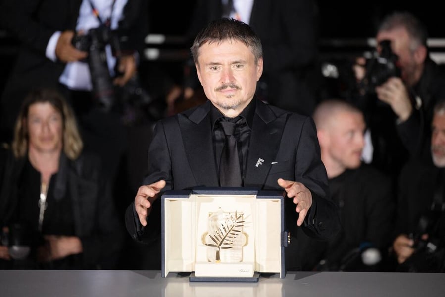 Romanian director Cristian Mungiu poses with the Palme d'Or trophy after winning the top prize at the 79th Cannes Film Festival
