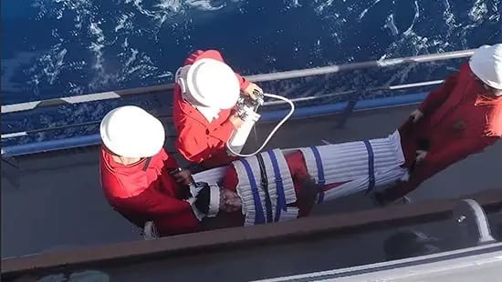 Health officials in protective gear conducting quarantine inspection aboard cruise ship after hantavirus outbreak