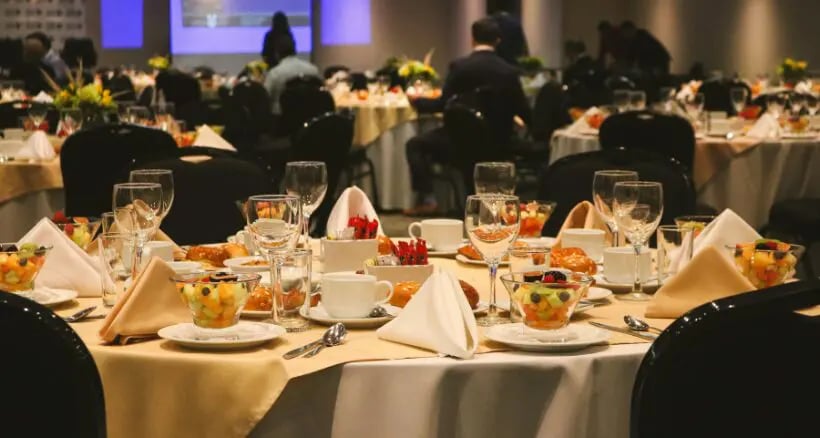 Empty chairs and dimly lit political fundraising dinner table symbolizing donor hesitation
