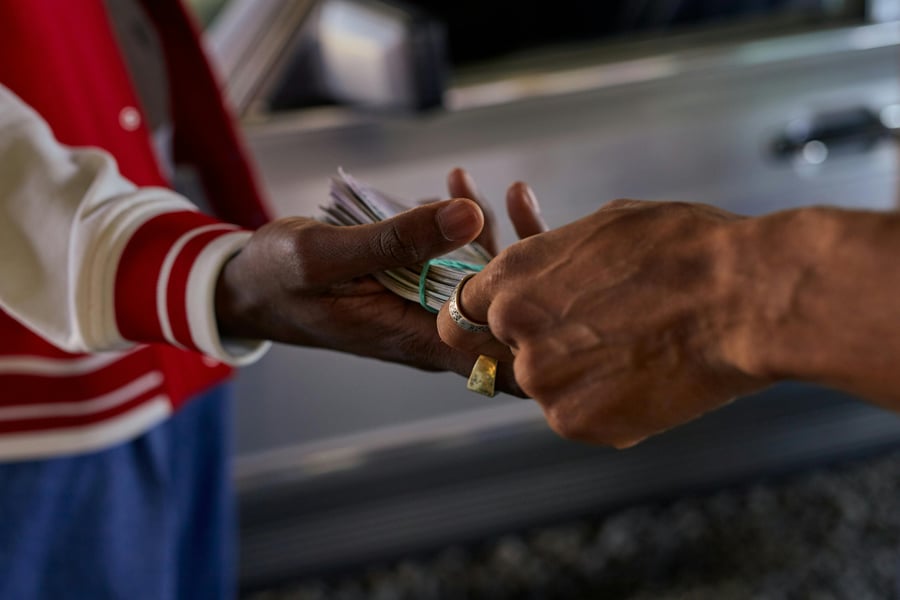 Hands exchanging envelope symbolizing political donor influence in US election campaigns