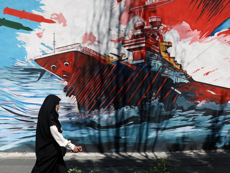 A Tehran mural depicts a US aircraft carrier under attack as the US and Iran weigh a ceasefire deal