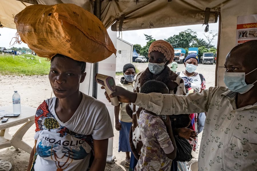 Border officer checks traveler temperature at Busunga crossing between Uganda and Democratic Republic of Congo
