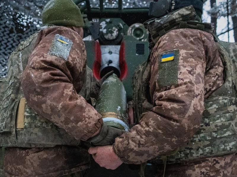 Ukrainian servicemen load an artillery shell on the Kharkiv front during the Russia-Ukraine war