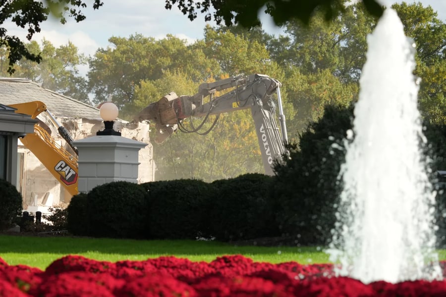 Construction workers on the U.S. Treasury roof watch the largely demolished East Wing of the White House on October 23, 2025