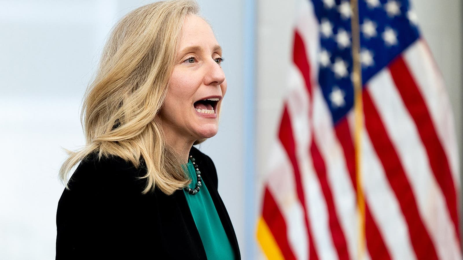 Virginia Governor Abigail Spanberger stands in front of an American flag