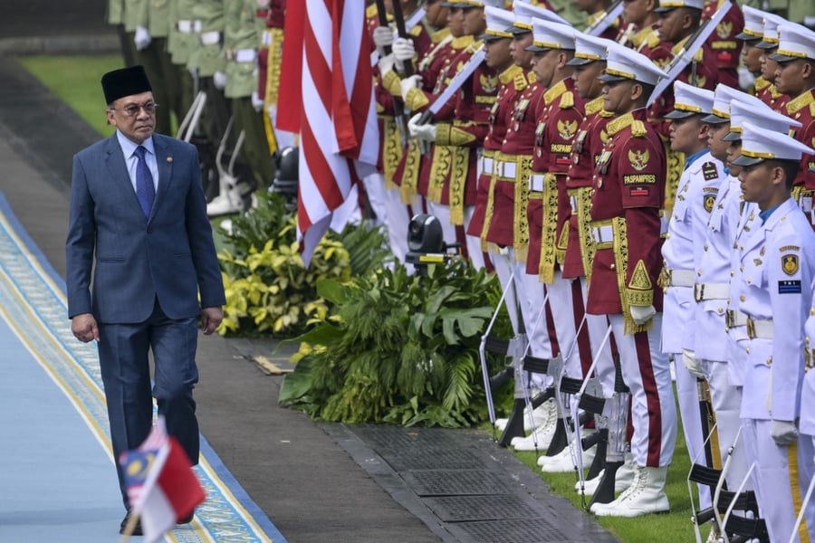 Malaysian Prime Minister Anwar Ibrahim inspects an honour guard during an official visit