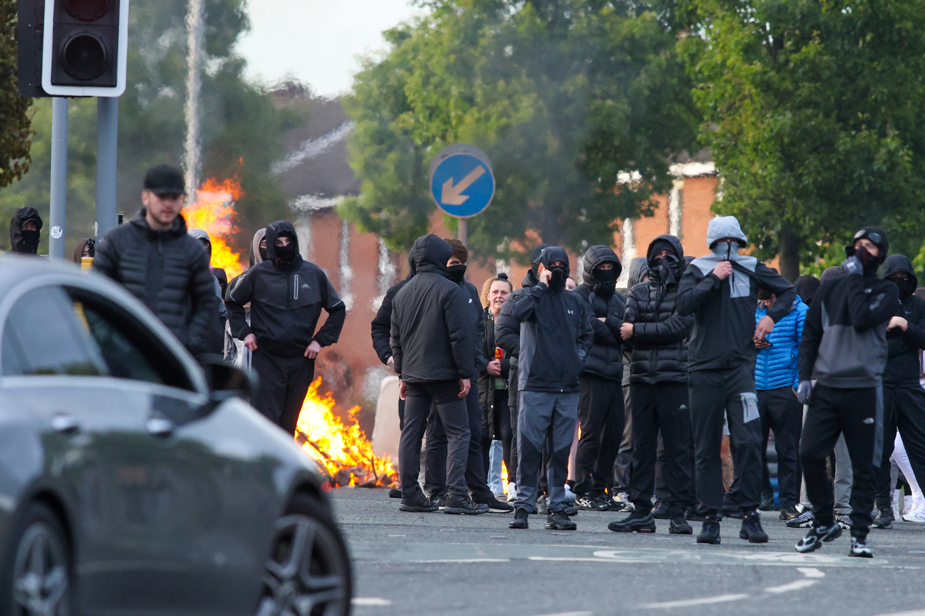 Masked youths block a road with burning debris in north Belfast Northern Ireland June 2026