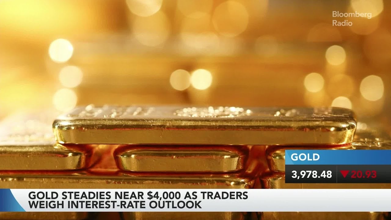 Gold bars and trading charts as gold settles near $4,000 per ounce