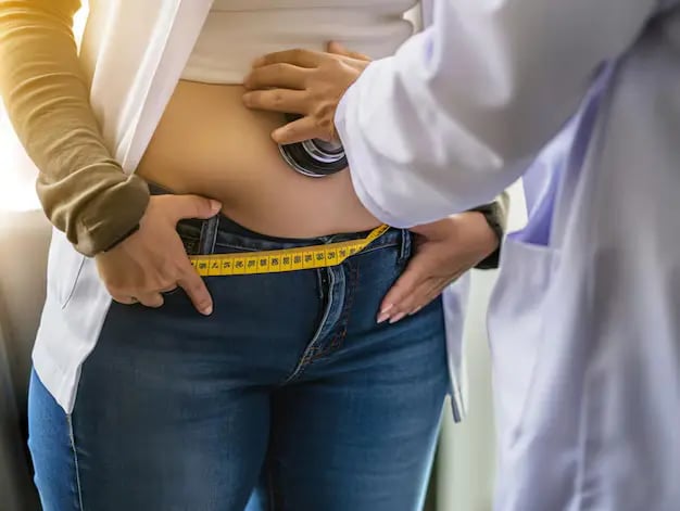 A doctor measuring a patient's waist circumference as an alternative to BMI for obesity diagnosis