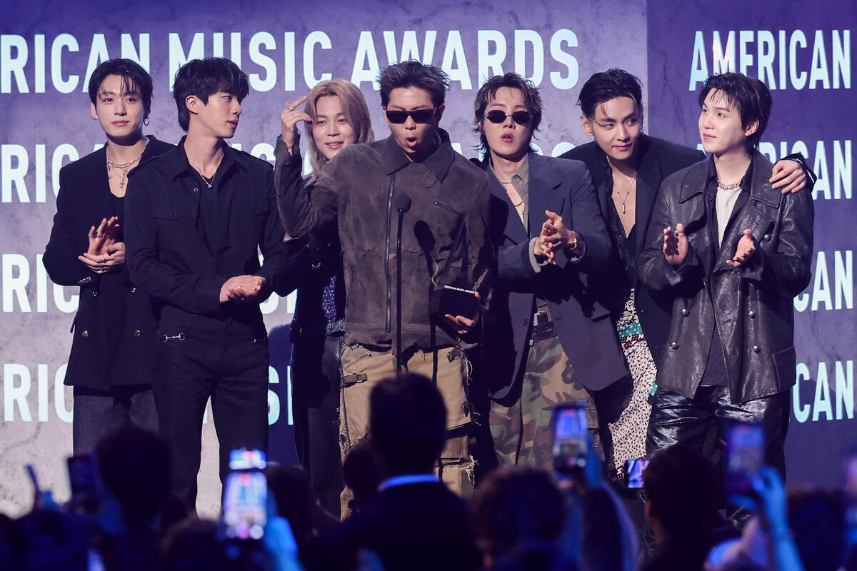 BTS members accepting the Artist of the Year award on stage at the 2026 American Music Awards at MGM Grand Garden Arena in Las Vegas