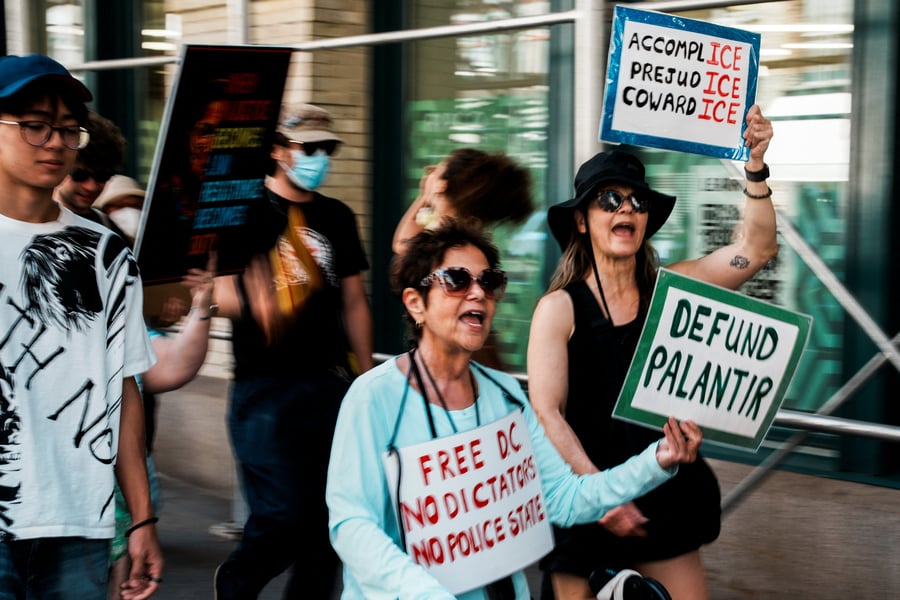 Protesters hold signs reading defund Palantir during a march outside Palantir's offices in New York