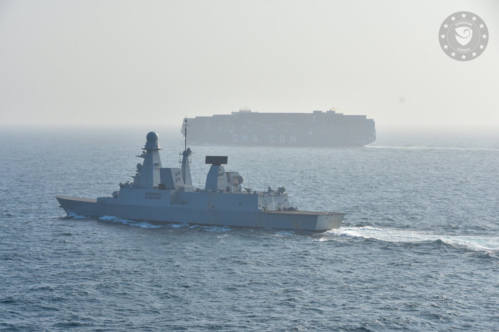 EUNAVFOR warship escorts a container ship through the Red Sea as part of EU Operation ASPIDES