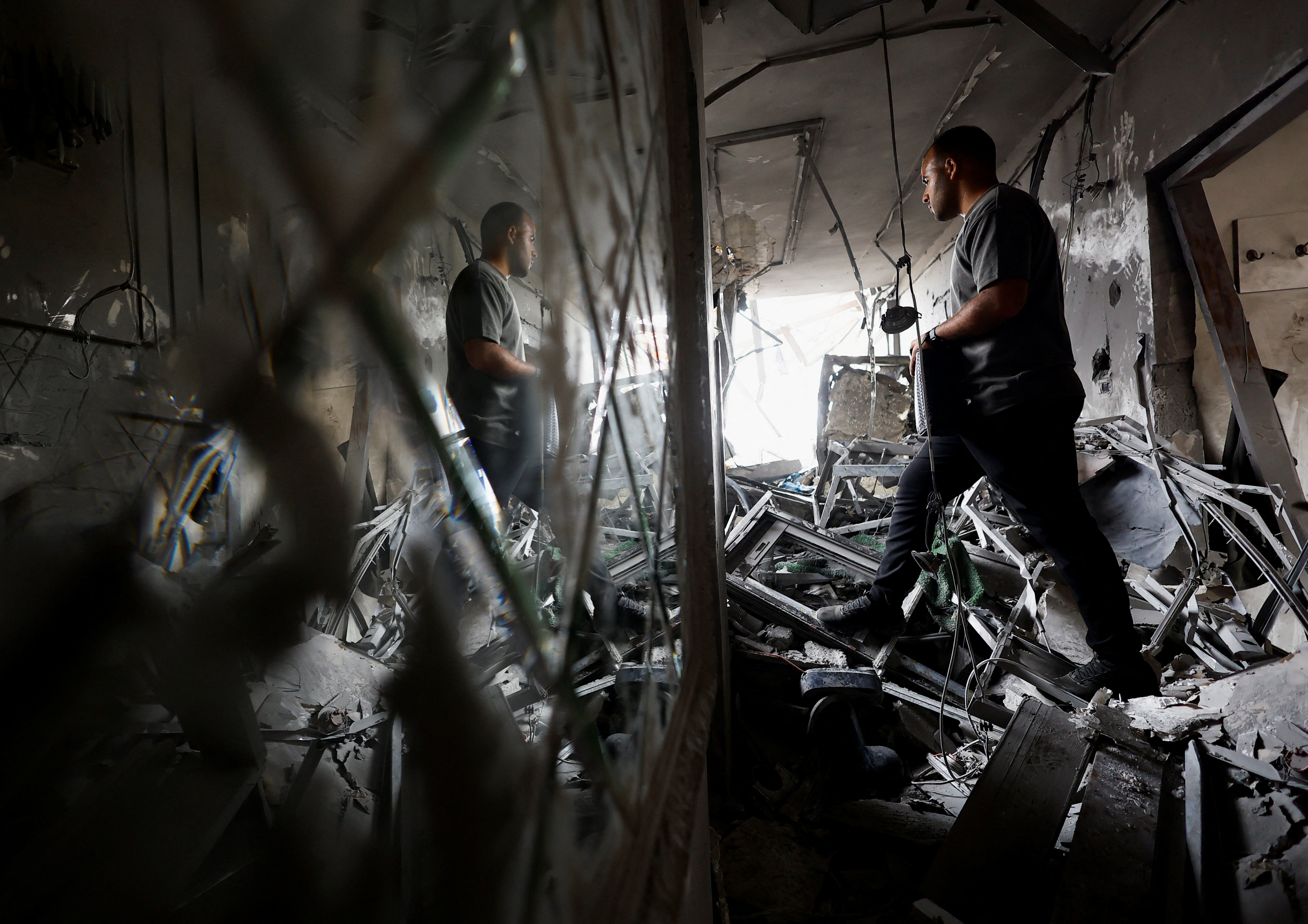 A Palestinian resident examines debris from an Israeli air strike on a residential building in Gaza City