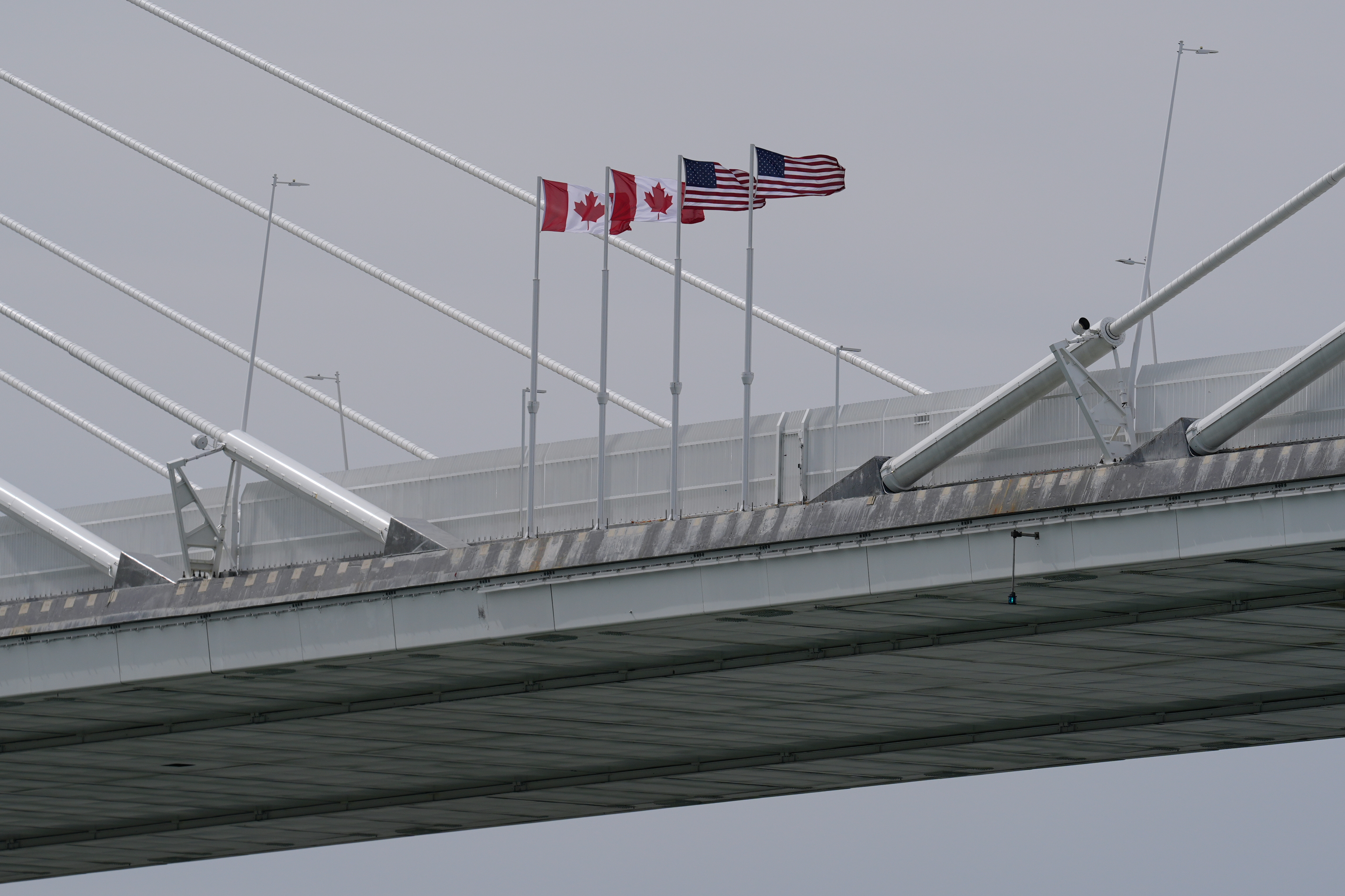 Canadian and US flags fly on the Gordie Howe International Bridge connecting Windsor, Ontario and Detroit