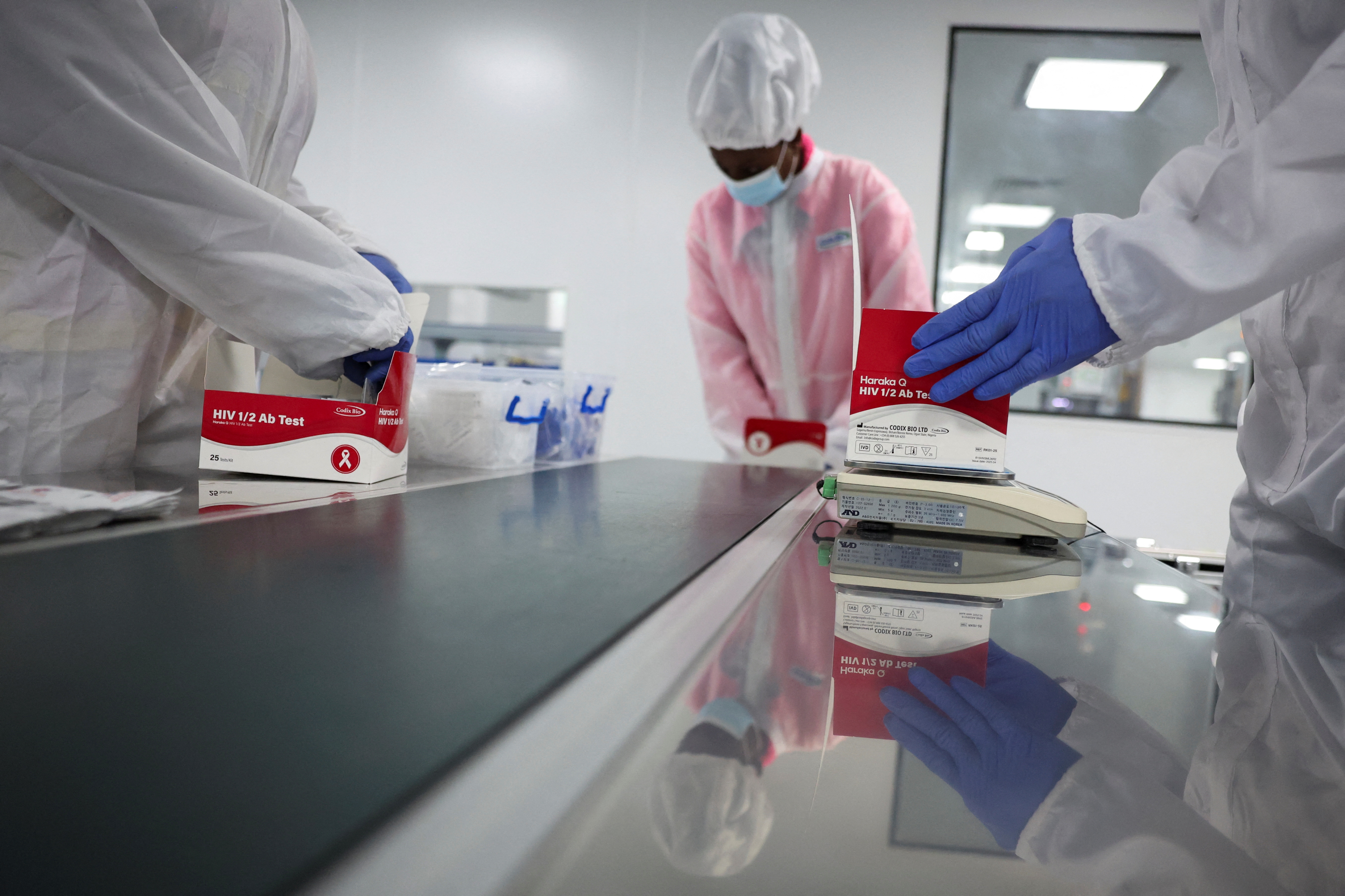 Workers package HIV test kits at a production facility in Nigeria