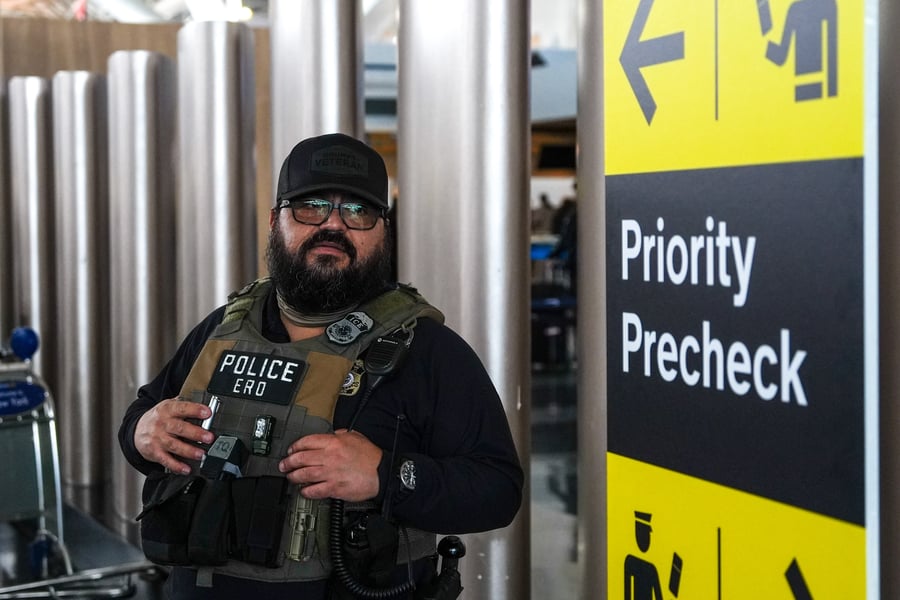 A federal immigration agent patrols John F Kennedy International Airport in New York