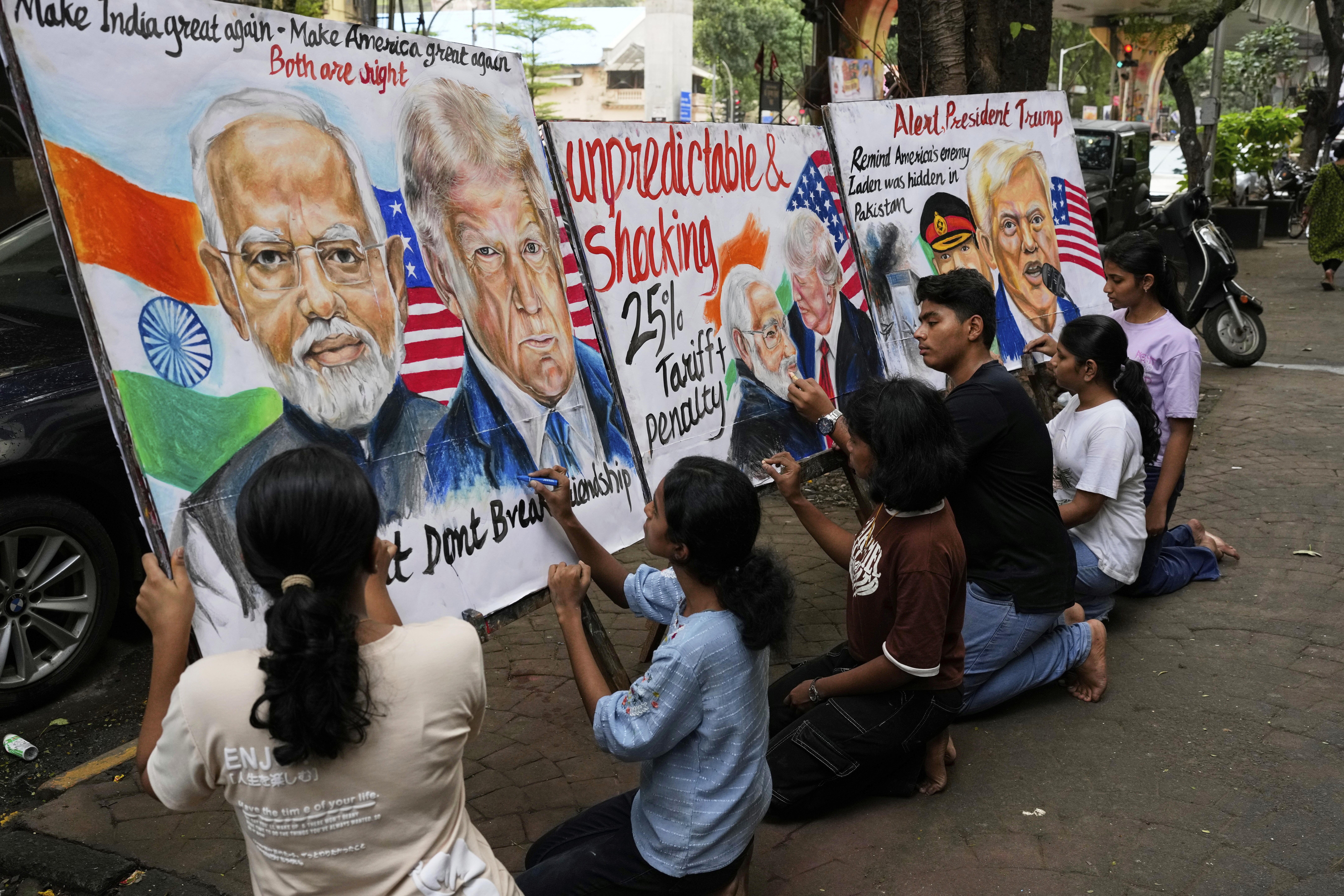 Students work on paintings of US President Donald Trump in Mumbai, India