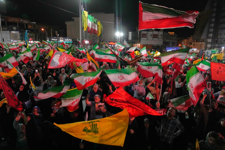 Pro-government Iranian demonstrators wave flags of Iran and Hezbollah in Tehran, June 7, 2026