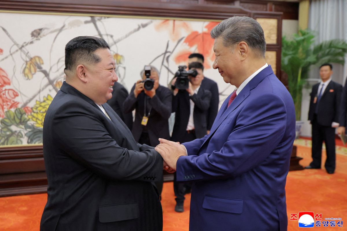 North Korean leader Kim Jong Un shakes hands with Chinese President Xi Jinping at a summit in Beijing