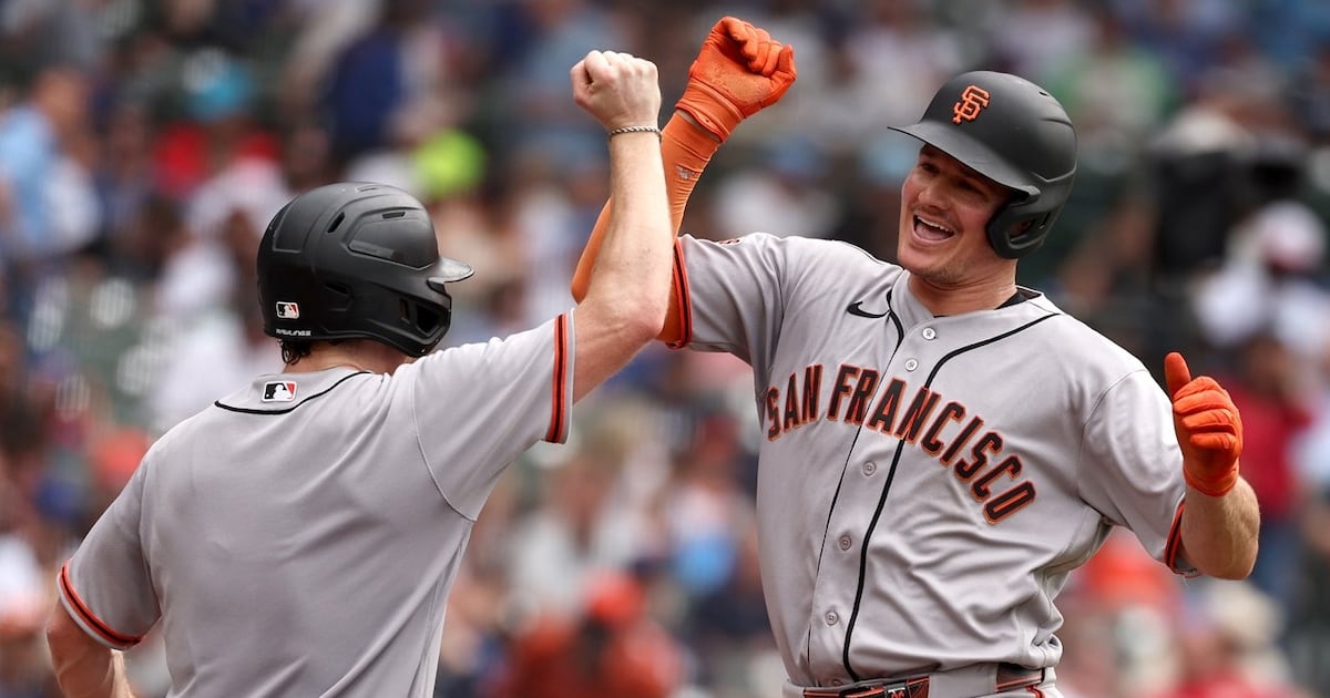 Matt Chapman of San Francisco Giants celebrates with bat boy after hitting three-run home run against Chicago Cubs at Wrigley Field