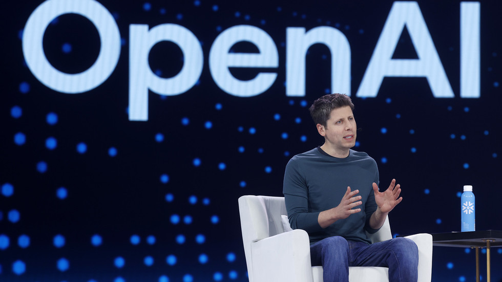 OpenAI chief executive Sam Altman seated on stage in front of a large OpenAI logo