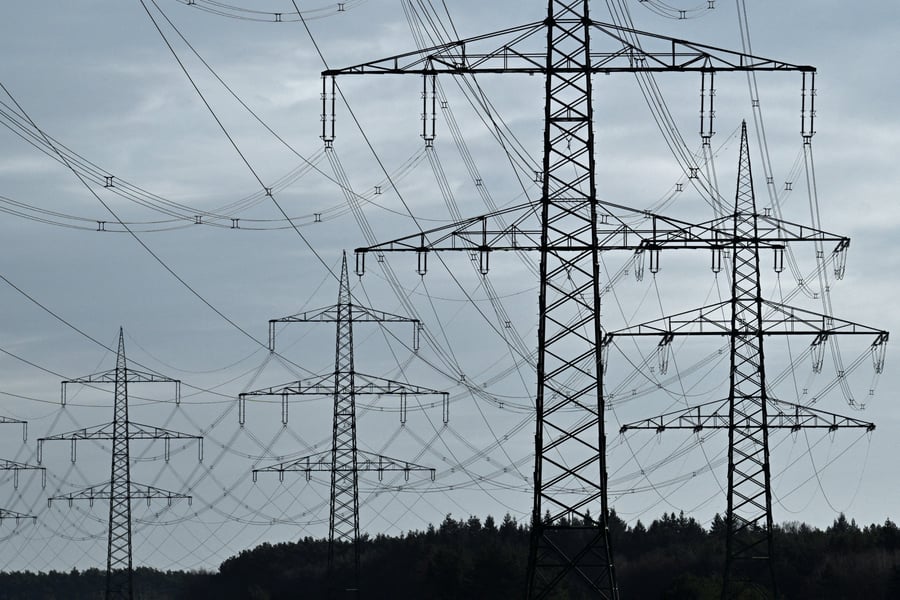 High-voltage power lines and electricity pylons near the A24 motorway in Germany, illustrating the COP31 electrification target