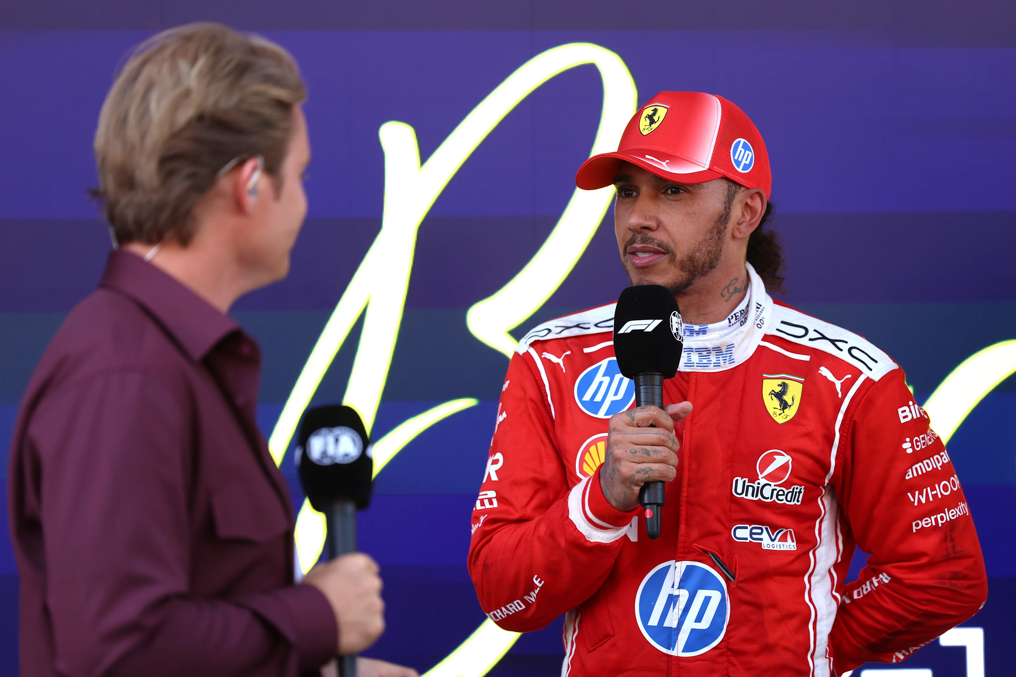 Nico Rosberg interviewing Lewis Hamilton in parc ferme after Hamilton's first Ferrari win at the 2026 Barcelona-Catalunya Grand Prix