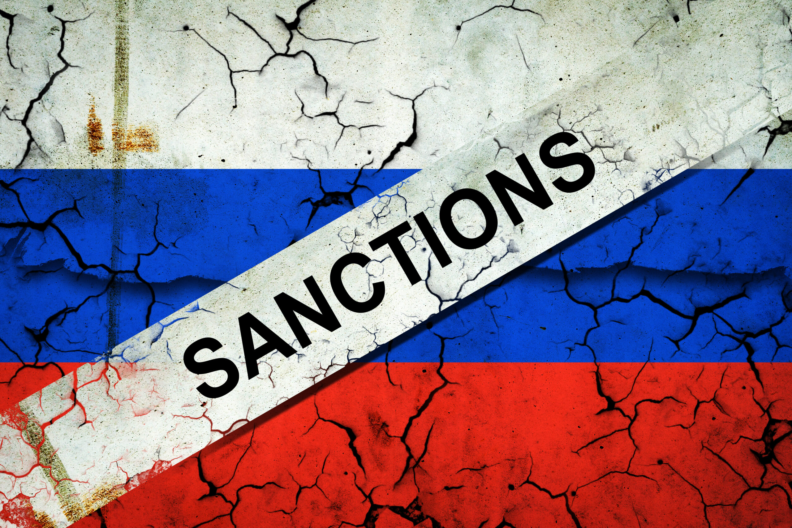 Cracked Russian flag symbolising EU oil price cap sanctions against Russia crude