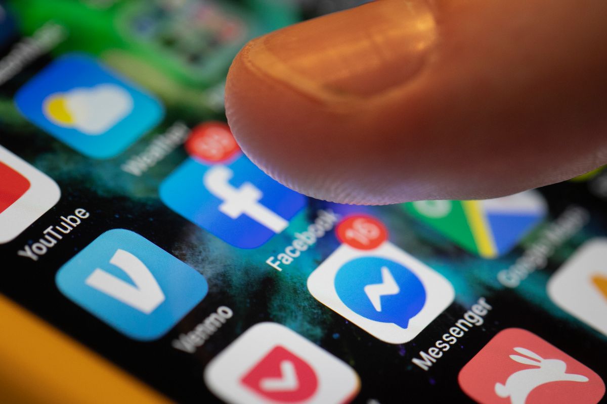 A smartphone displays Facebook and Messenger icons amid debate over a social media ban for children