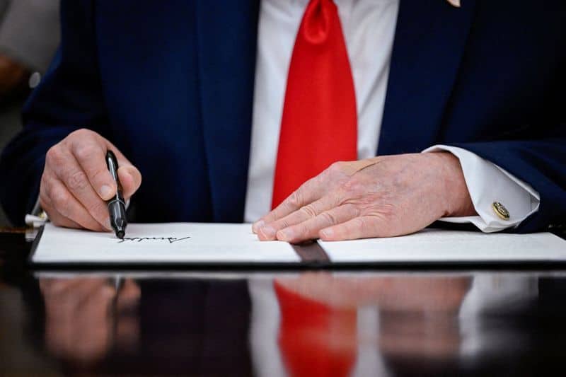 Donald Trump signing a proclamation at the White House in June 2026, as new Reuters/Ipsos polling shows his approval among rural voters has declined sharply