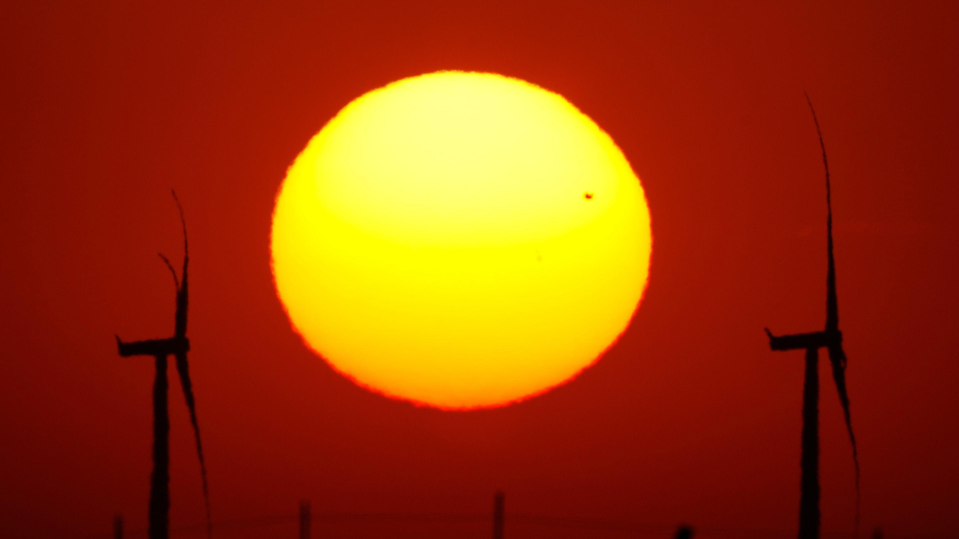 Wind turbines silhouetted at sunset in a field near Cimarron, Kansas, where Pentagon reviews have stalled new wind projects