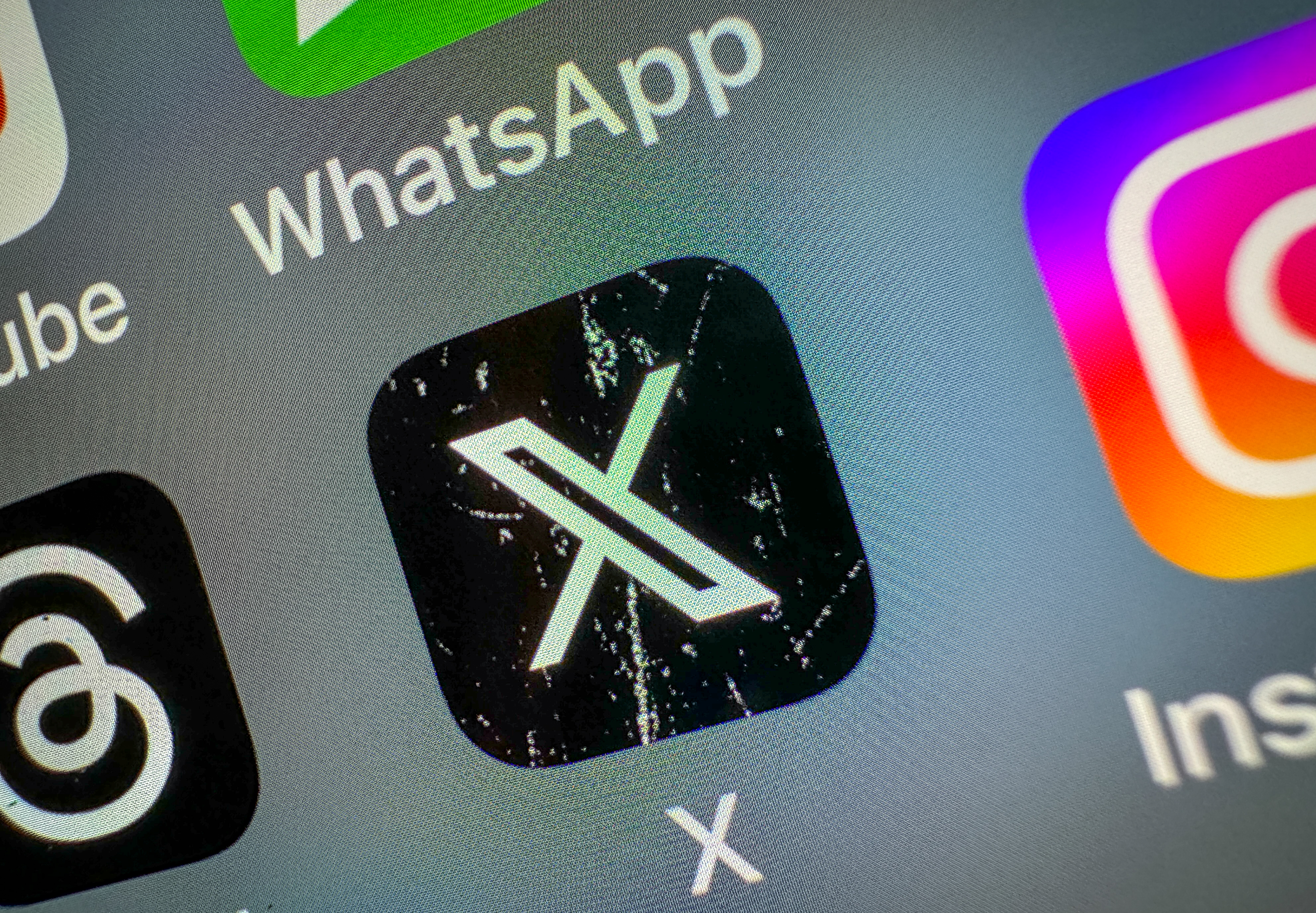 X app icon on smartphone screen showing React with Video feature coming to Android and iOS