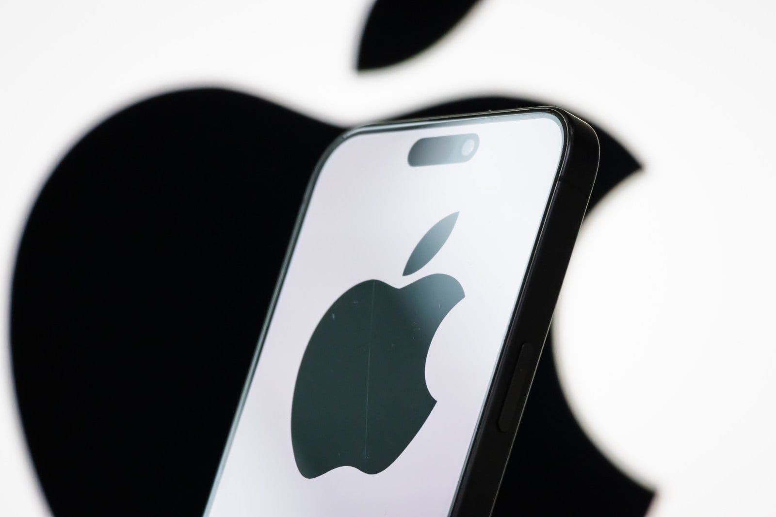 Photo illustration of the Apple logo displayed on a smartphone screen