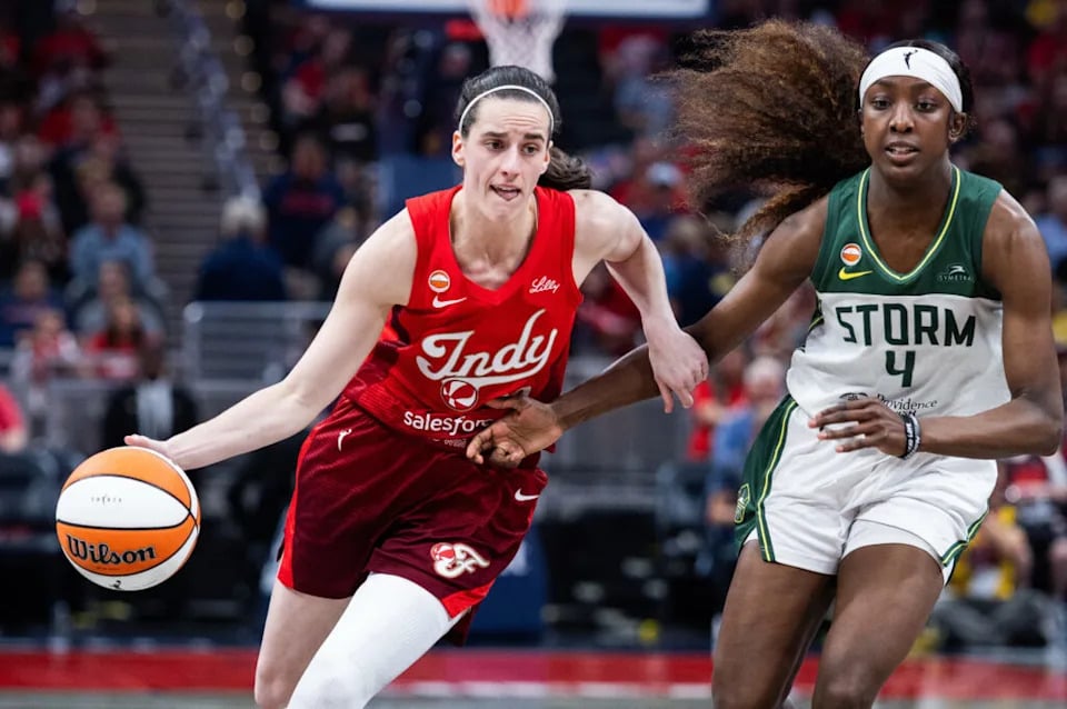 Caitlin Clark driving against Seattle Storm guard Flau’jae Johnson at Gainbridge Fieldhouse