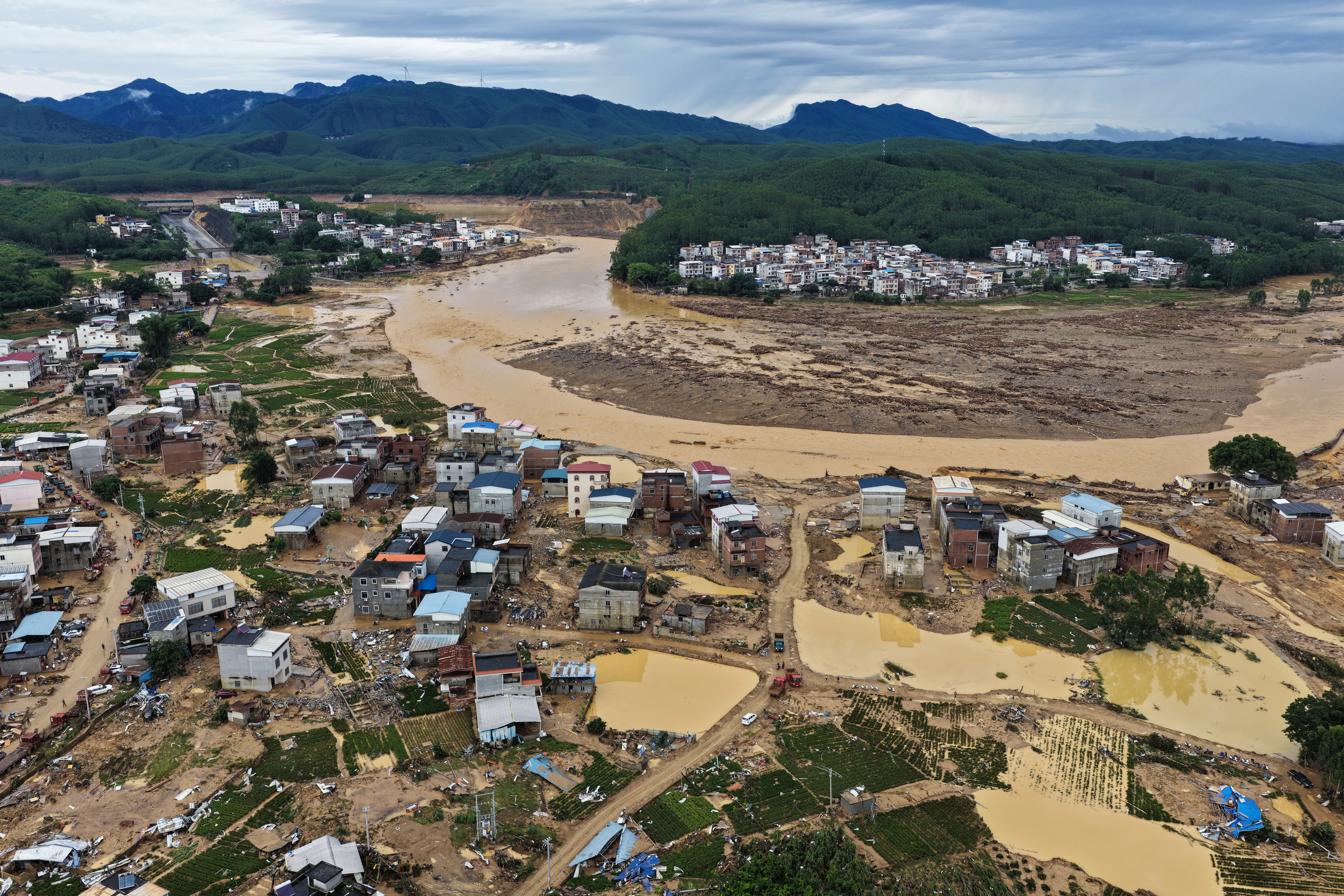Floodwaters breach the Liulan Reservoir dam in Guangxi, China, during Tropical Storm Maysak, causing deadly flooding downstream in Nanning, July 2026.