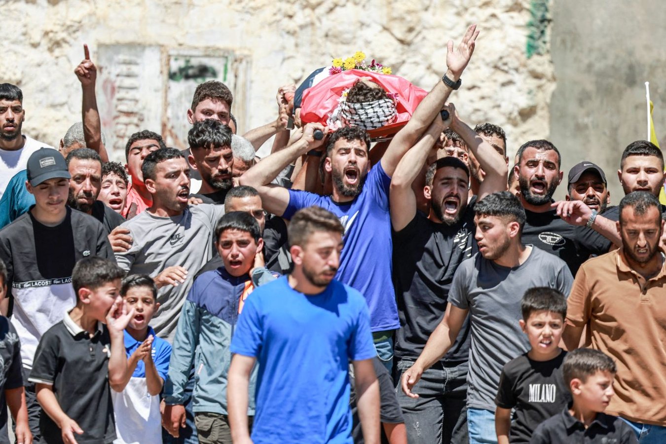 Mourners gather for the funeral of Fadi al-Nassan, the 17-year-old Palestinian footballer killed after being shot during a settler attack in the West Bank