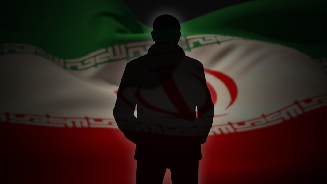 Silhouette of a person against the Iranian flag, illustrating Iran-linked espionage arrests in Israel