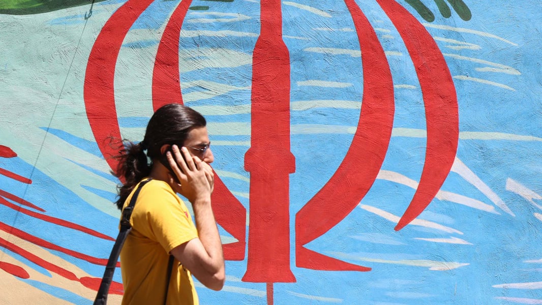 An Iranian man walks past an anti-US and anti-Israel mural in Tehran, May 2026